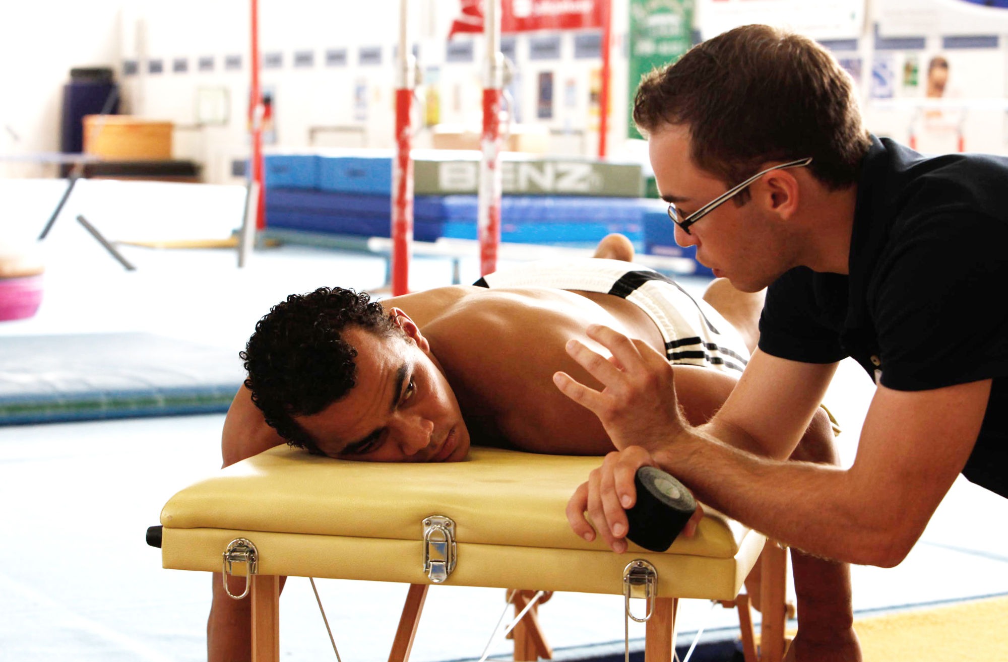 das bild zeigt einen leichtathleten der auf einer liege liegt und eine sportmassage erhällt - halle saale